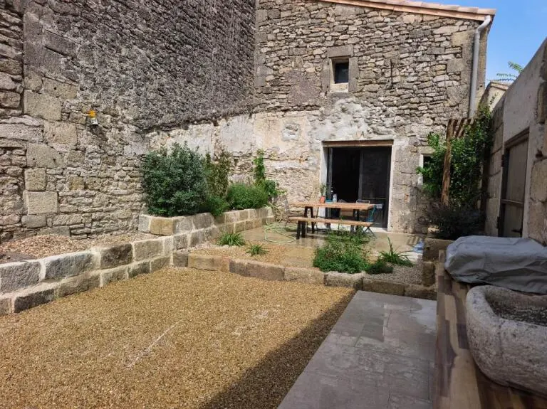 Après : cour en pierre transformée en espace de vie avec gravier et plantations