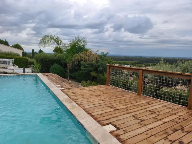 Terrasse bois au bord d'une piscine avec garde-corps